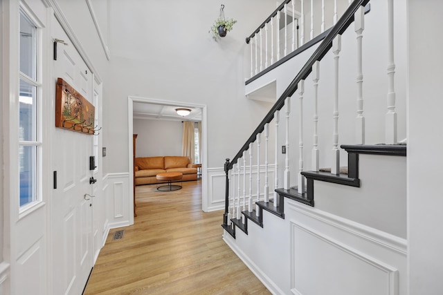 534 Creekridge Rd, Aiken, SC 29803 - entrance foyer featuring light wood finished floors, stairway, a towering ceiling, a decorative wall, and wainscoting