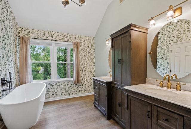 534 Creekridge Rd, Aiken, SC 29803 - bathroom with wallpapered walls, vaulted ceiling, two vanities, a freestanding bath, and wood finished floors