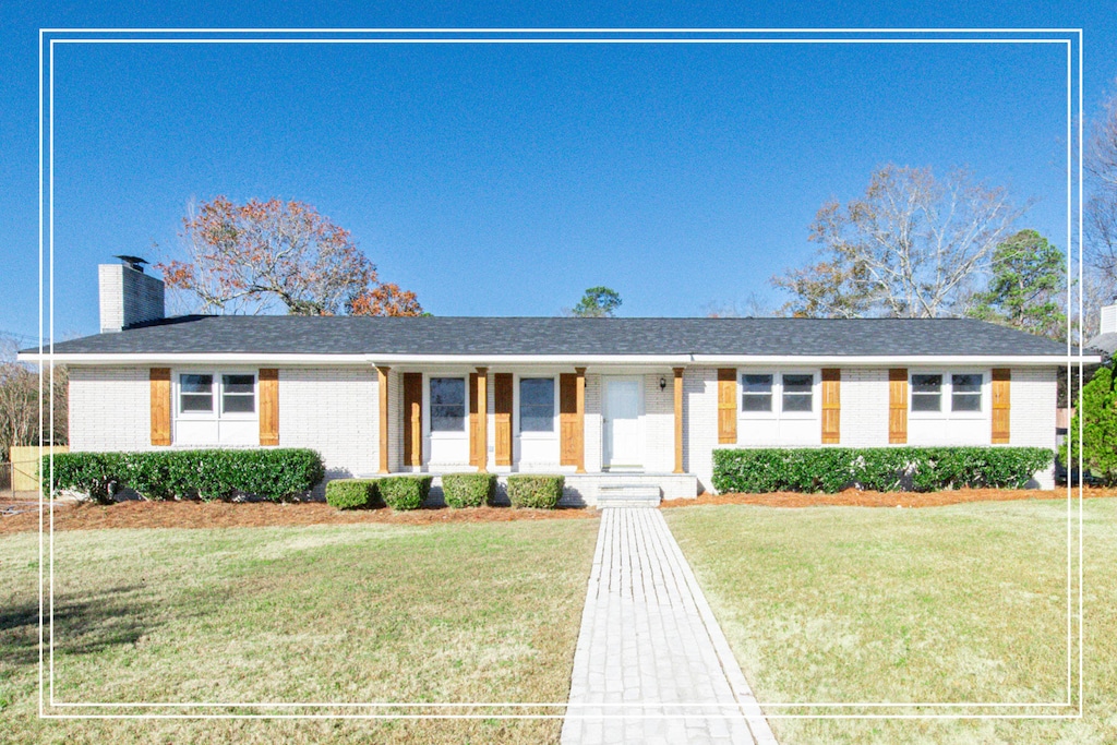 ranch-style home with a front lawn