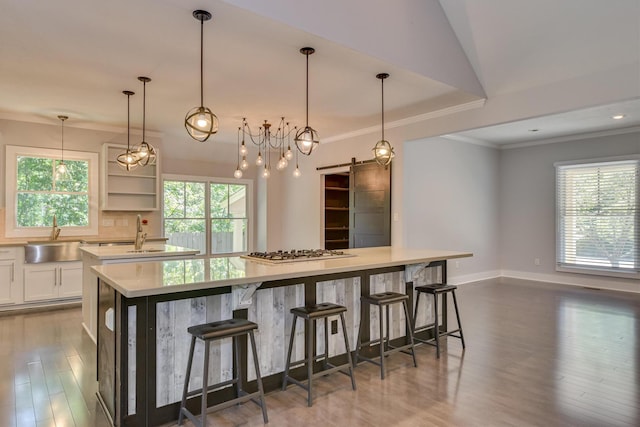 525 Brigham Trl, Augusta, GA 30909 - kitchen with a barn door, a large island, white cabinets, stainless steel gas cooktop, and wood finished floors