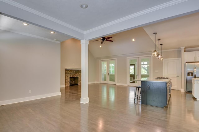 525 Brigham Trl, Augusta, GA 30909 - kitchen featuring stainless steel appliances, open floor plan, white cabinetry, a kitchen breakfast bar, and decorative columns