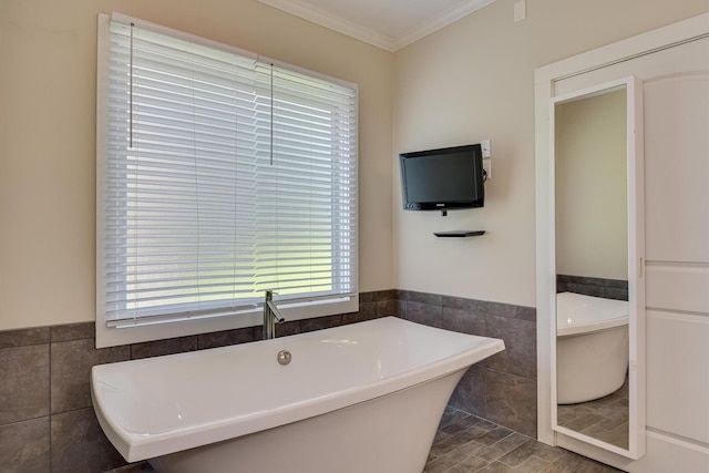 525 Brigham Trl, Augusta, GA 30909 - bathroom featuring tile walls, ornamental molding, a soaking tub, plenty of natural light, and a wainscoted wall
