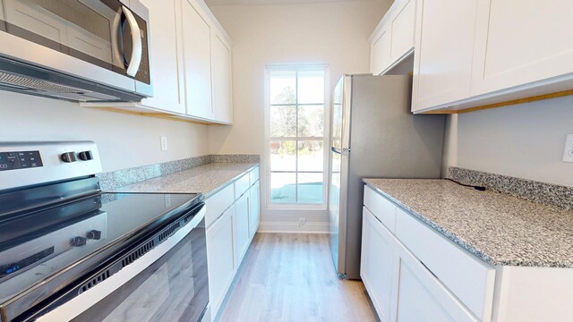 kitchen featuring white cabinetry, sink, stainless steel dishwasher, and light stone counters