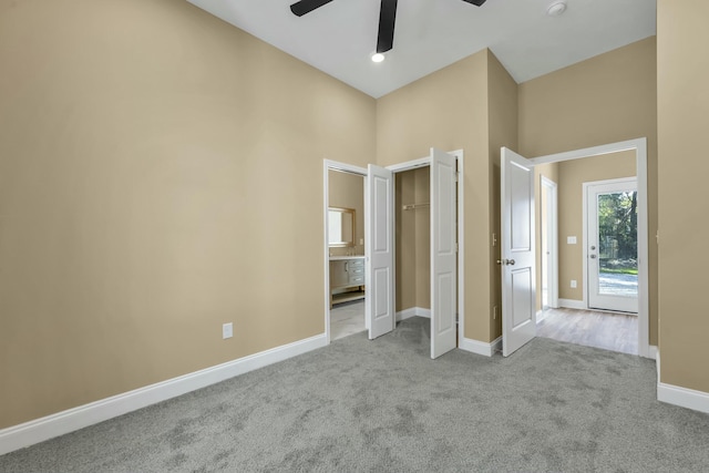 unfurnished bedroom featuring ensuite bath, ceiling fan, and light colored carpet