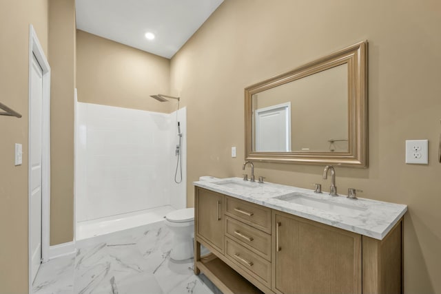 bathroom with vanity, toilet, and a shower