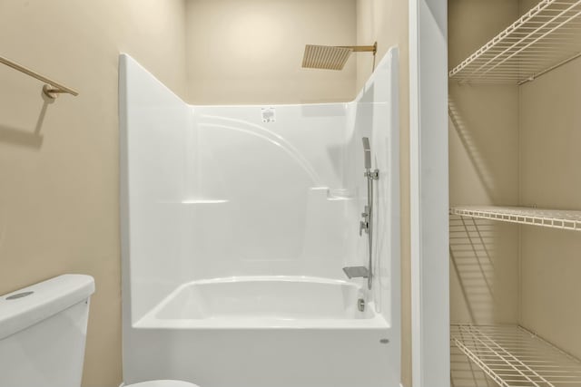 bathroom with toilet and washtub / shower combination