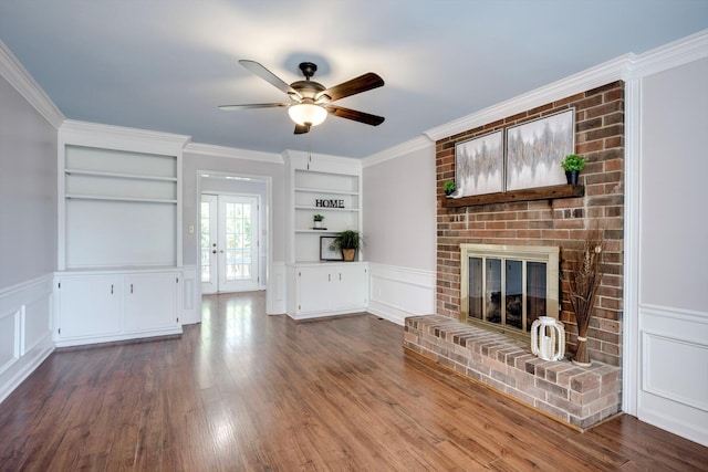 123 Sugar Maple Ln, Martinez, GA 30907 - unfurnished living room featuring a decorative wall, built in shelves, ceiling fan, a brick fireplace, and crown molding