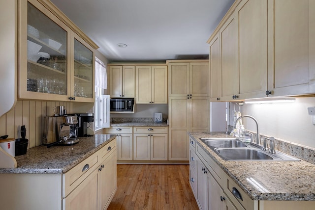 3011 Fox Spring Rd, Augusta, GA 30909 - kitchen featuring black microwave, light wood-style floors, glass insert cabinets, light brown cabinetry, and light stone countertops