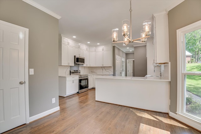 4 Shadowmoor Ct, North Augusta, SC 29841 - kitchen featuring stainless steel appliances, a chandelier, crown molding, white cabinets, and light countertops