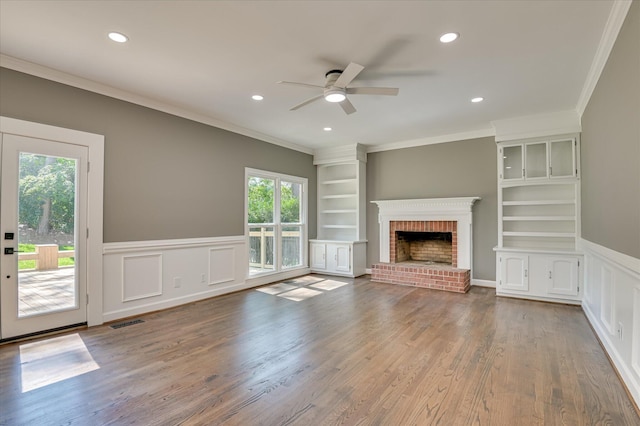 4 Shadowmoor Ct, North Augusta, SC 29841 - unfurnished living room featuring ornamental molding, a ceiling fan, a fireplace, built in shelves, and a wainscoted wall