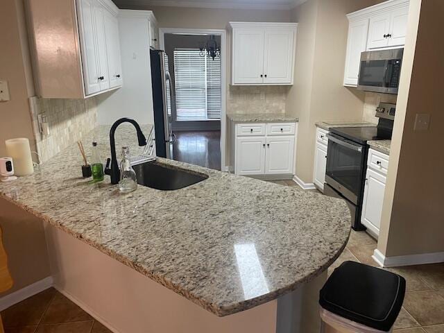 507 Julia Ct, Grovetown, GA 30813 - kitchen with appliances with stainless steel finishes, a sink, a peninsula, tasteful backsplash, and white cabinetry