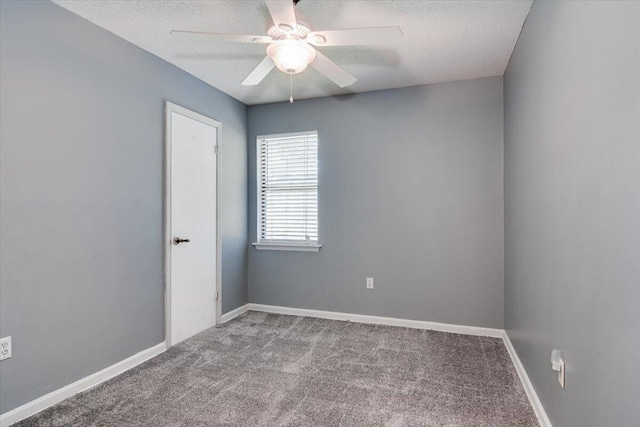 carpeted spare room featuring ceiling fan and a textured ceiling