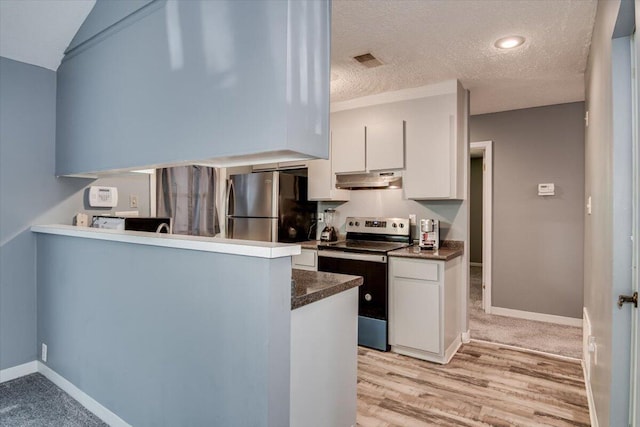 kitchen with white cabinets, appliances with stainless steel finishes, a textured ceiling, and light hardwood / wood-style flooring