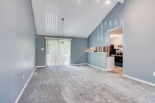 unfurnished living room with light carpet and high vaulted ceiling