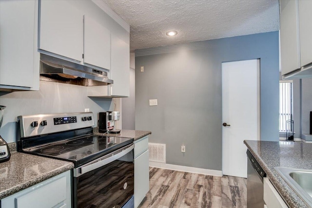 kitchen featuring appliances with stainless steel finishes, a textured ceiling, and white cabinetry