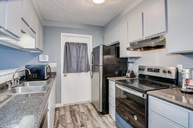 kitchen featuring sink, stainless steel appliances, light hardwood / wood-style flooring, a textured ceiling, and white cabinets