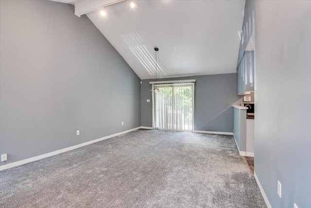 unfurnished living room with carpet flooring and lofted ceiling with beams