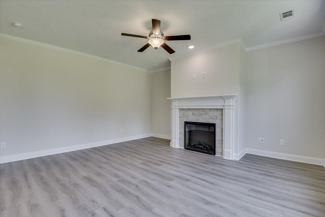 unfurnished living room featuring ceiling fan, a fireplace, ornamental molding, and light hardwood / wood-style flooring