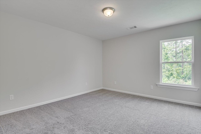 carpeted empty room with visible vents and baseboards