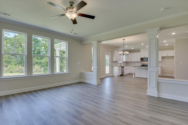 unfurnished living room with crown molding, light wood-style floors, visible vents, and ornate columns