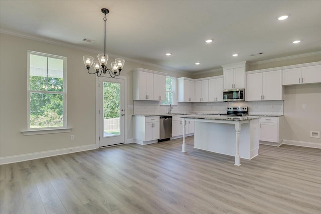 kitchen with a breakfast bar area, white cabinetry, a kitchen island, and appliances with stainless steel finishes