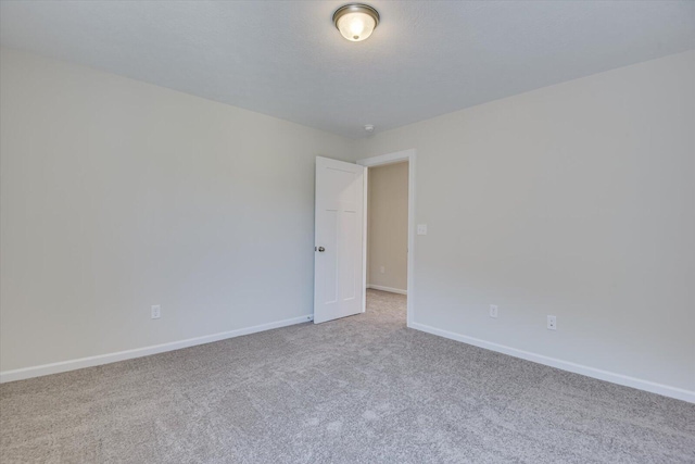 unfurnished room featuring light carpet