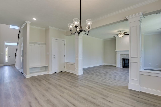 unfurnished living room featuring plenty of natural light, light hardwood / wood-style flooring, ceiling fan with notable chandelier, and ornamental molding