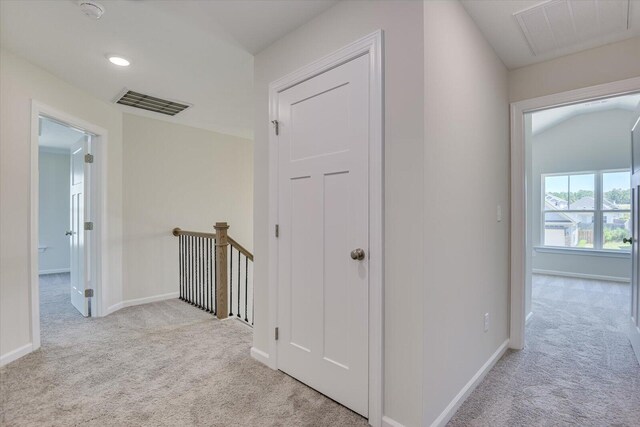 corridor with carpet flooring, visible vents, and baseboards