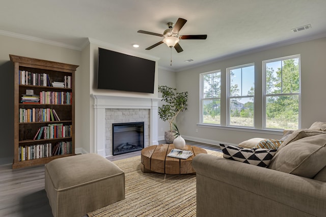 living area with crown molding, a brick fireplace, baseboards, and light wood-style floors