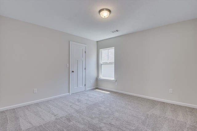 unfurnished room featuring carpet floors, visible vents, and baseboards