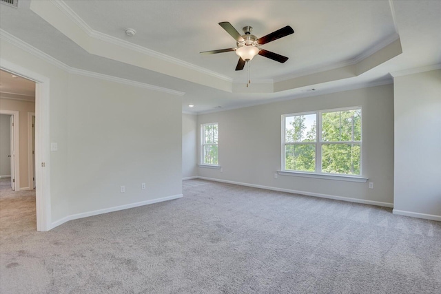 carpeted empty room featuring a tray ceiling, ceiling fan, and ornamental molding