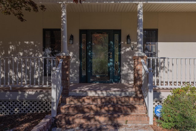 view of exterior entry with a porch