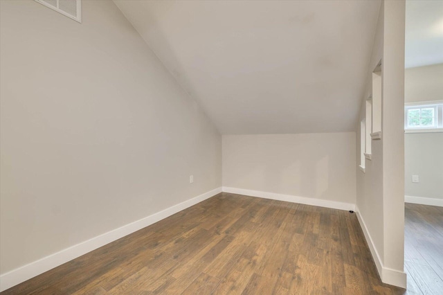 additional living space featuring dark hardwood / wood-style floors and lofted ceiling