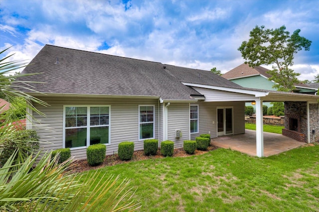 back of house with a lawn, a fireplace, and a patio