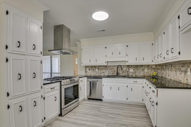 715 Gentlewind Ln, Martinez, GA 30907 - kitchen with appliances with stainless steel finishes, island exhaust hood, crown molding, white cabinets, and tasteful backsplash