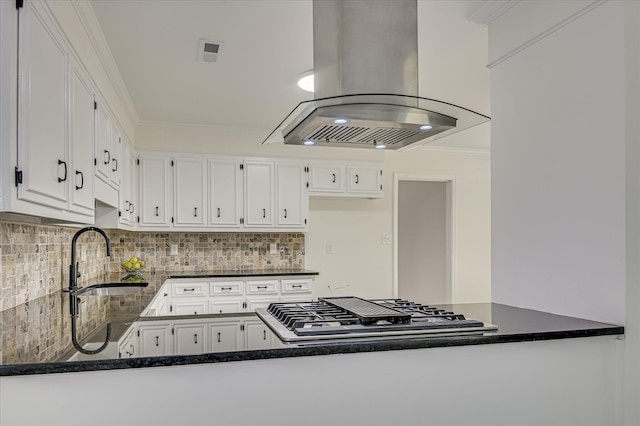 715 Gentlewind Ln, Martinez, GA 30907 - kitchen with island range hood, stainless steel gas cooktop, white cabinets, decorative backsplash, and a peninsula