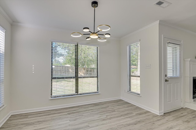 715 Gentlewind Ln, Martinez, GA 30907 - unfurnished dining area featuring a chandelier, ornamental molding, light wood-type flooring, healthy amount of natural light, and a fireplace
