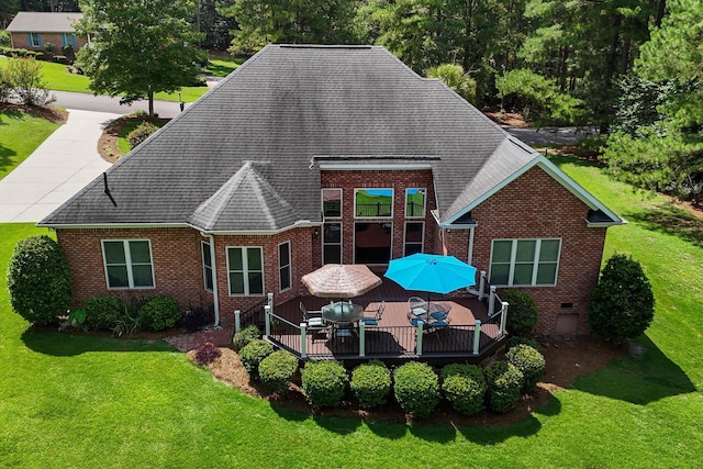 back of house featuring a lawn and a wooden deck