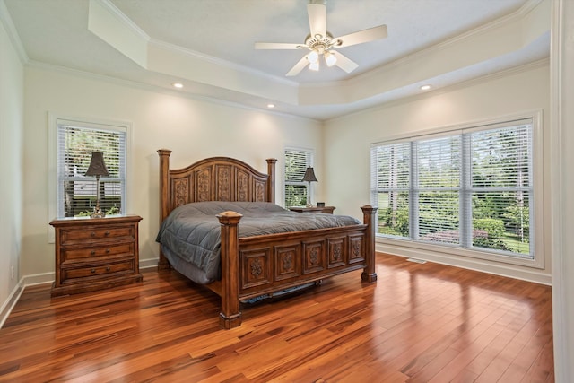 bedroom featuring dark hardwood / wood-style floors, a raised ceiling, ceiling fan, and crown molding