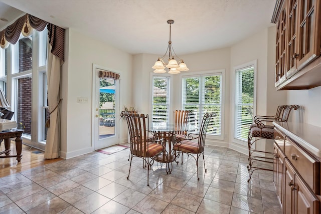 dining space featuring plenty of natural light and an inviting chandelier