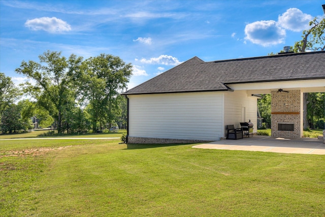 view of yard with ceiling fan, a brick fireplace, and a patio area