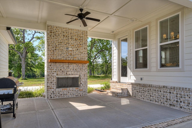 view of patio with a ceiling fan, entry steps, area for grilling, and an outdoor brick fireplace