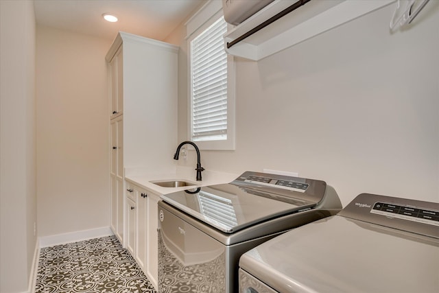 clothes washing area featuring cabinet space, independent washer and dryer, a sink, recessed lighting, and baseboards