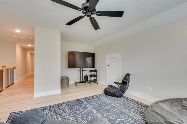 bedroom with baseboards, light wood finished floors, and attic access