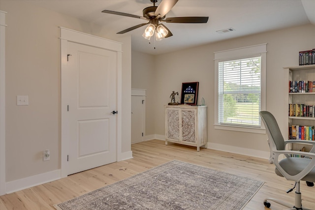 home office with visible vents, a ceiling fan, baseboards, and wood finished floors