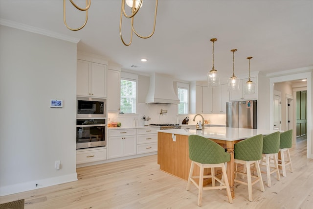 kitchen featuring light wood-style floors, appliances with stainless steel finishes, backsplash, and custom exhaust hood