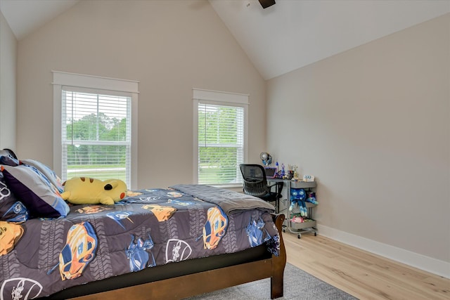 bedroom with baseboards, high vaulted ceiling, ceiling fan, and wood finished floors