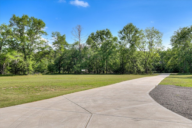 exterior space with concrete driveway and a yard
