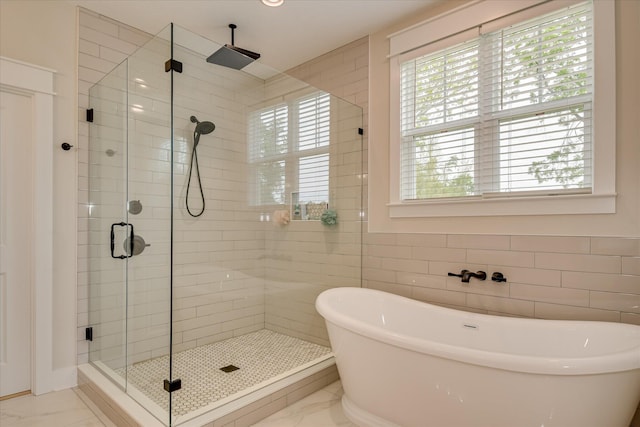 bathroom featuring tile walls, a soaking tub, a shower stall, and marble finish floor