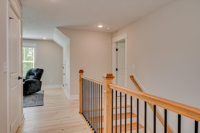 corridor with recessed lighting, light wood finished floors, baseboards, and an upstairs landing
